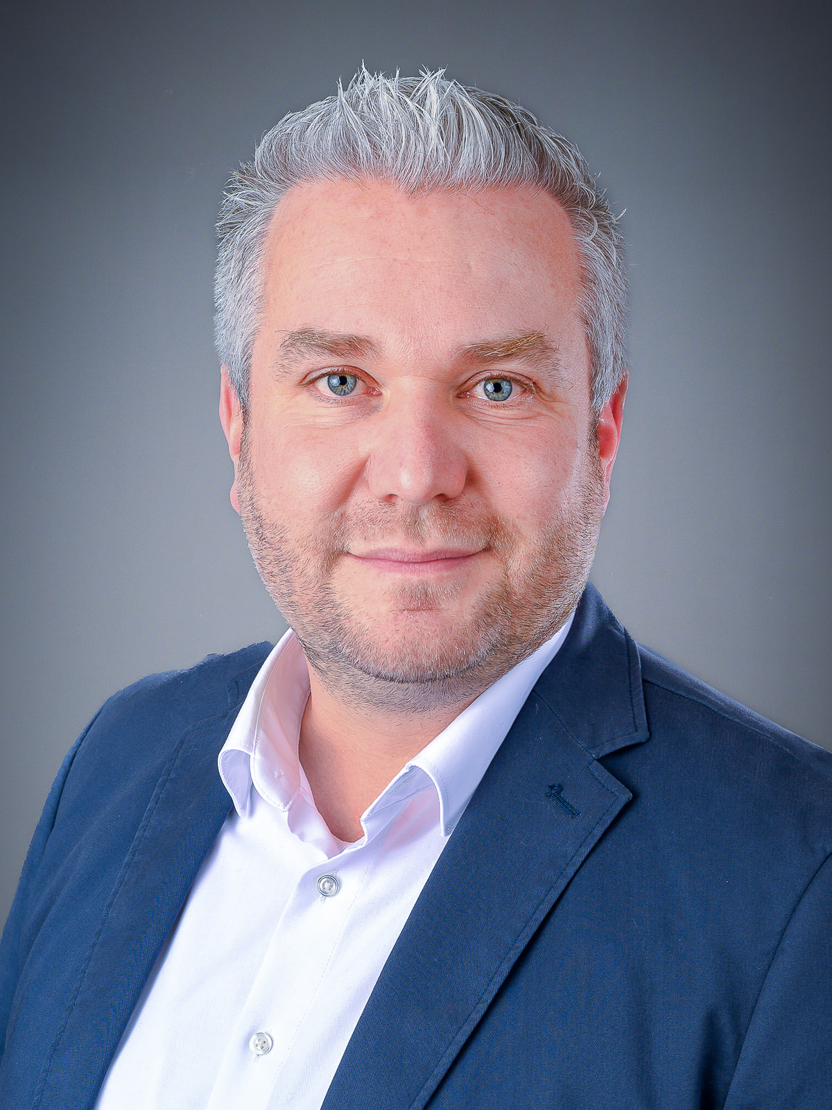 Professionelles Bewerbungsfoto eines Mannes im Business-Outfit vor neutralem Hintergrund