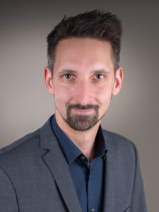 Professionelles Bewerbungsfoto eines Mannes im grauen Anzug vor neutralem Hintergrund