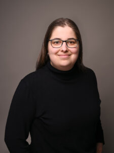 Professionelles Bewerbungsfoto im Fotostudio in Donauwörth, junge Frau mit natürlichem Lächeln vor dunklem Hintergrund.