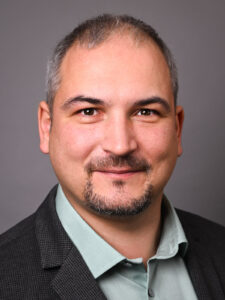 Professionelles Business-Porträt eines Mannes im Fotostudio in Donauwörth, freundlicher Ausdruck vor neutralem Hintergrund.