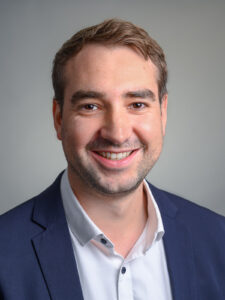 Professionelles Business-Porträt eines Mannes im Fotostudio in Donauwörth, freundlicher Ausdruck vor neutralem Hintergrund.