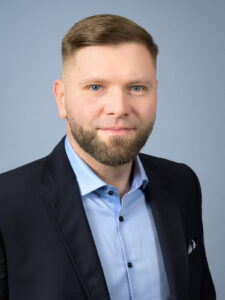 Business-Porträt eines Mannes vor neutralem Hintergrund.