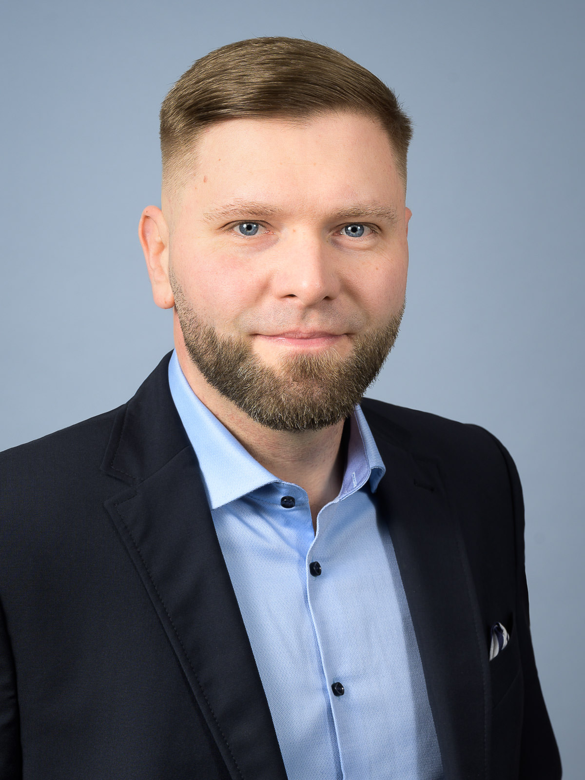 Business-Porträt eines Mannes vor neutralem Hintergrund.